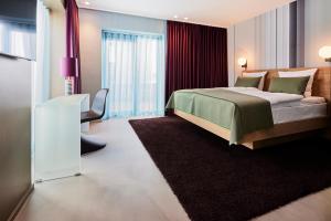 a bedroom with a bed and a chair in it at Kirk Suites in Vejle