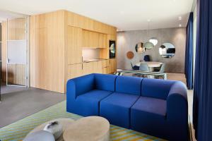 a living room with a blue couch and a table at Kirk Suites in Vejle