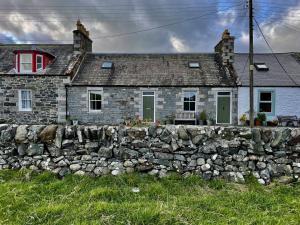 an old stone house behind a stone wall at Apple Cottage in Newton Stewart