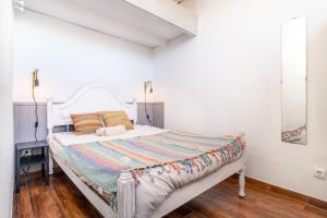 ein weißes Schlafzimmer mit einem Bett mit einem weißen Kopfteil in der Unterkunft Casa do Vento Townhouse in Aljezur