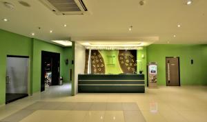 a store lobby with green walls and a cash register at Zodiak MT Haryono by KAGUM Hotels in Jakarta