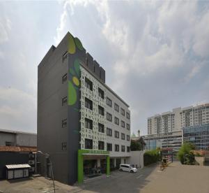 un edificio alto blanco con un verde en Zodiak MT Haryono by KAGUM Hotels en Yakarta