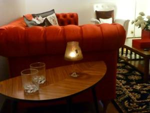 an orange couch with two glasses on a table at Apartamento Vintage 1 in Porto