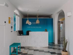 un hall avec un comptoir et un mur bleu dans l'établissement Hostal Las Gaviotas del Cabo, à San José