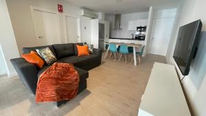 a living room with a black couch and a table at Txoko Loft Bardenas in Tudela