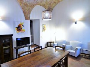 uma sala de estar com uma grande mesa de madeira e cadeiras em Borgo Petrarca Il Mulino em Mantignana