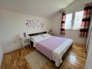 1 dormitorio con 1 cama grande y 2 ventanas en Apartmani Roje Sveti Filip I Jakov, en Sveti Filip i Jakov