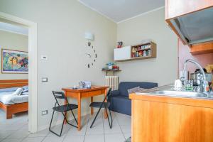 uma cozinha com um lavatório, uma mesa e um sofá em River Apartment - Affitti Brevi Italia em Lecco