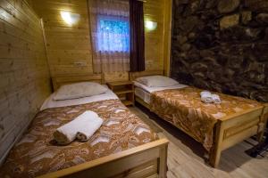 Dos camas en una cabaña de madera con toallas. en house by the river, en Mestia