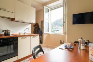 uma cozinha com uma mesa de madeira e uma cozinha com uma janela em River Apartment - Affitti Brevi Italia em Lecco