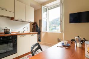 a kitchen with a wooden table and a kitchen with a window at River Apartment - Affitti Brevi Italia in Lecco