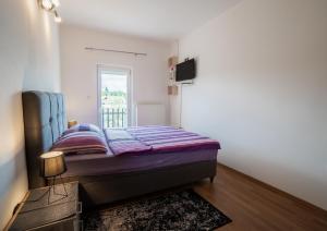 a small bedroom with a bed and a television at Apartman Filip in Gospić
