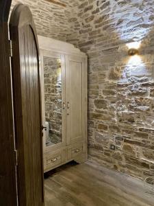 baño con espejo y pared de piedra en Cozy stone built apartment in Nénita!, en Chios