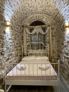 1 dormitorio con 1 cama en una pared de ladrillo en Cozy stone built apartment in Nénita!, en Chios