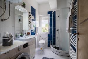 a blue and white bathroom with a sink and a toilet at Apartman Filip in Gospić