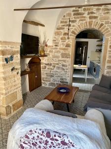 sala de estar con sofá y pared de piedra en Cozy stone built apartment in Nénita!, en Chios