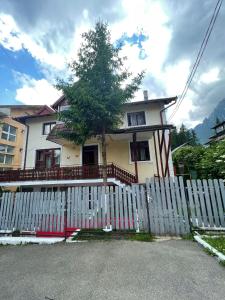 una cerca blanca frente a una casa en CONSTANTINESCU A., en Buşteni