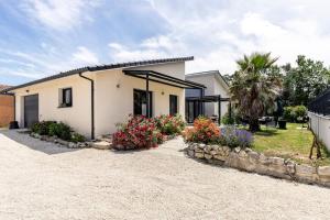 a house with flowers in front of it at Villa des rives du Tarn avec jacuzzi in Montans