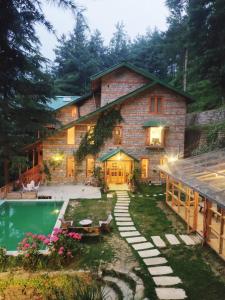 an exterior view of a house with a swimming pool at Kudrat - A Boutique Homestay- Tirthan Valley in Banjār