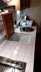 Una pequeña cocina con fregadero y estufa. en La casa di Aaron, en Montevarchi