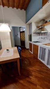 una cocina con una mesa y una estufa horno superior en La casa di Aaron, en Montevarchi 4 fotos más