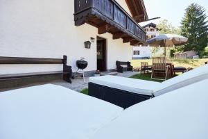 a backyard with a patio with a table and an umbrella at Ferienwohnung Hubert in Rottach-Egern