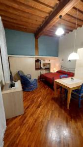 Una sala de estar con una cama y una mesa con sillas. en La casa di Aaron, en Montevarchi