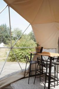 Tienda con sillas, mesa, mesa, mesa y silla en Glamping Dome Tent en Jubbega-Schurega