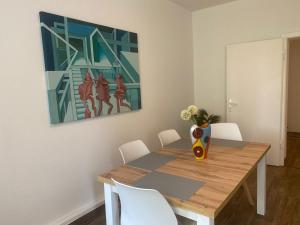 een eetkamer met een tafel en een vaas met bloemen bij Art-Appartement in Bielefeld