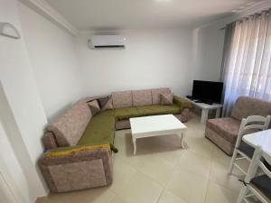 a living room with a couch and a tv at Loft Apartments in Sarandë