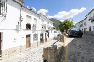 a car driving down a street with white buildings at Casa Paula in Benamahoma