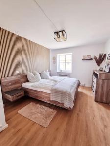 ein Schlafzimmer mit einem großen Bett und Holzboden in der Unterkunft Traumhafte Auszeit in Bad Lauchstädt