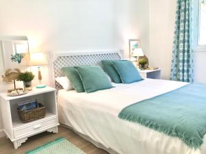 1 dormitorio con 1 cama blanca grande con almohadas azules en Casa Costera Fragata en San Andrés