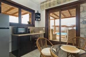 a kitchen with a table and chairs and a television at Michaliou Kipos Luxury Villas in Afiartis