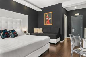 a bedroom with a large white bed and a couch at Reggia Suite Spa Hotel in Caserta