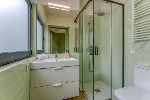 La salle de bains est pourvue d'un lavabo et d'une douche en verre. dans l'établissement Travel and Live Apartments, à Porto