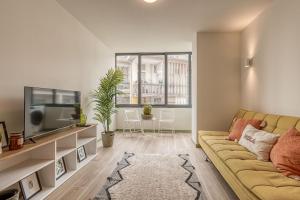 - un salon avec un canapé et une télévision dans l'établissement Travel and Live Apartments, à Porto