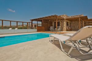 Michaliou Kipos Luxury Villas في Afiartis: فيلا بمسبح وكرسيين جلوس