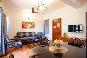 ein Wohnzimmer mit einem Sofa und einem Tisch in der Unterkunft 'Golden Coral' 2bhk Benaulim Beach villa Goa in Margao
