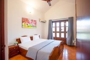 une chambre avec un grand lit et une fenêtre dans l'établissement 'Golden Coral' 2bhk Benaulim Beach villa Goa, à Benaulim