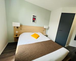 a bedroom with a bed with a yellow towel on it at The Originals City, Hotel Novella Confort, Nantes Est in Carquefou