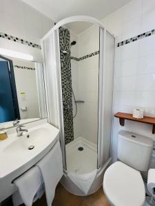 a bathroom with a shower and a sink and a toilet at The Originals City, Hotel Novella Confort, Nantes Est in Carquefou