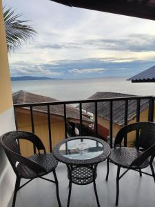 balcón con mesa, sillas y vistas al océano en Golden Beach Resort Koh Phangan, en Baan Tai