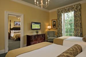 a hotel room with two beds and a television at The Otesaga Resort Hotel in Cooperstown