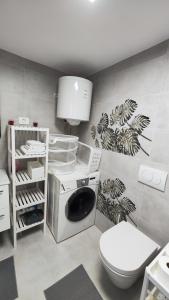 a bathroom with a washing machine and a toilet at Apartma ALTER EGO in Koper