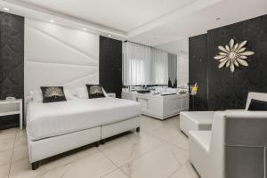 a bedroom with a white bed and a bathroom at Reggia Suite Spa Hotel in Caserta