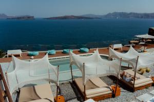um resort com piscina, cadeiras e água em Hotel Goulielmos em Acrotíri