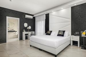 1 dormitorio con cama blanca y paredes negras en Reggia Suite Spa Hotel, en Caserta