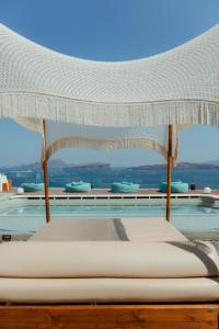 a bedroom with a canopy bed and a pool at Hotel Goulielmos in Akrotiri