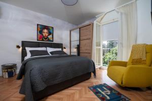 ein Schlafzimmer mit einem Bett und einem gelben Stuhl in der Unterkunft Queen Apartment Zadar in Zadar